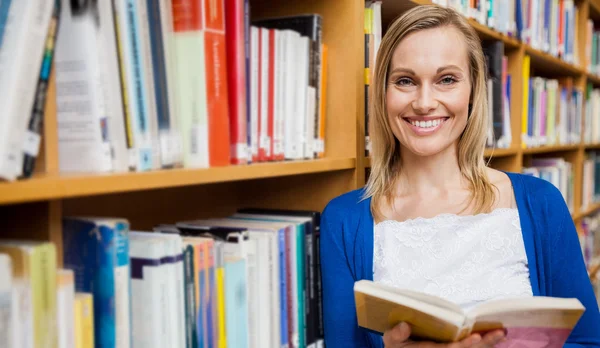 Kvinnlig student läser bok i biblioteket — Stockfoto