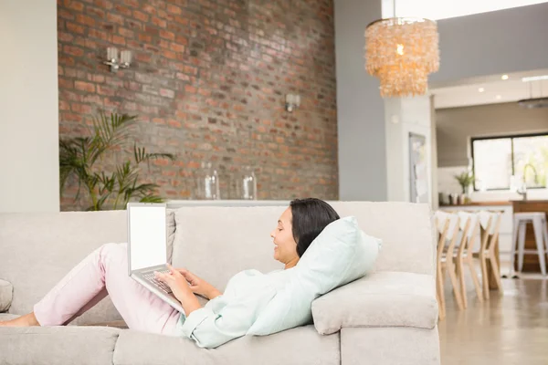 Lachende brunette met behulp van laptop — Stockfoto