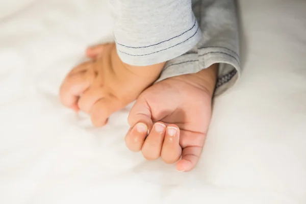 Handen van baby op bed — Stockfoto