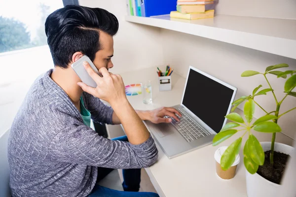 Homem ocupado usando smartphone e laptop — Fotografia de Stock