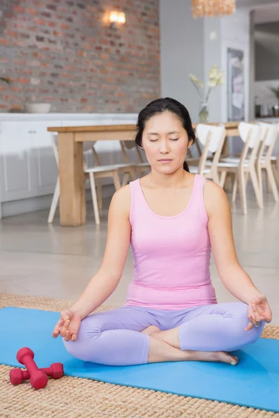 Lugn kvinna gör yoga på mattan — Stockfoto