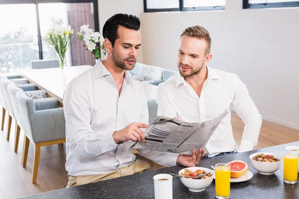 Gay couple reading newspaper — Stock Photo, Image