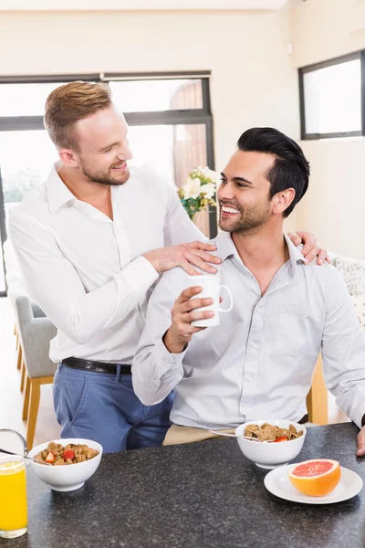 Smiling gay couple having breakfast — Stock Photo, Image