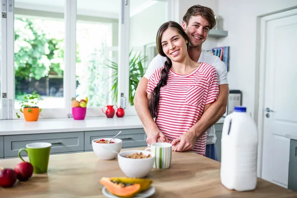 Lykkelig par som står på kjøkkenet – stockfoto