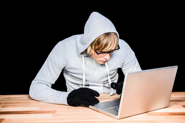 Man in kap jas hacken een laptop — Stockfoto