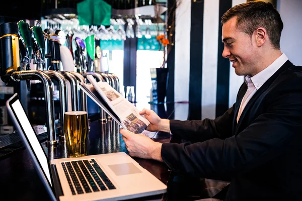 Geschäftsmann liest Nachrichten und nutzt Laptop — Stockfoto