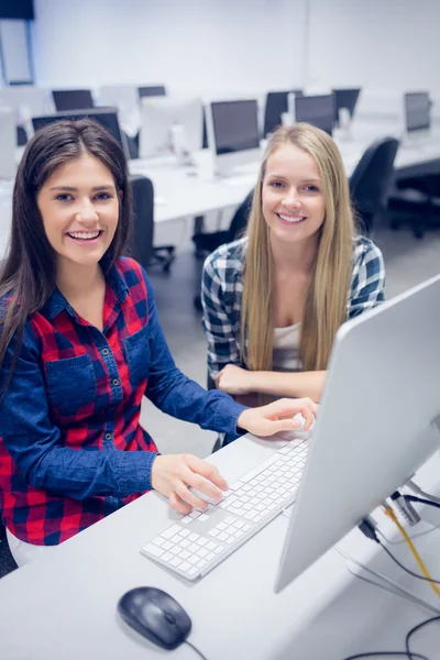 Estudantes sorrindo usando o computador — Fotografia de Stock