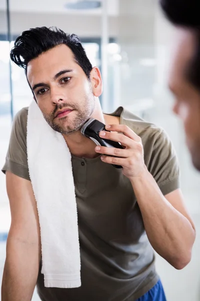Hombre guapo usando afeitadora eléctrica — Foto de Stock