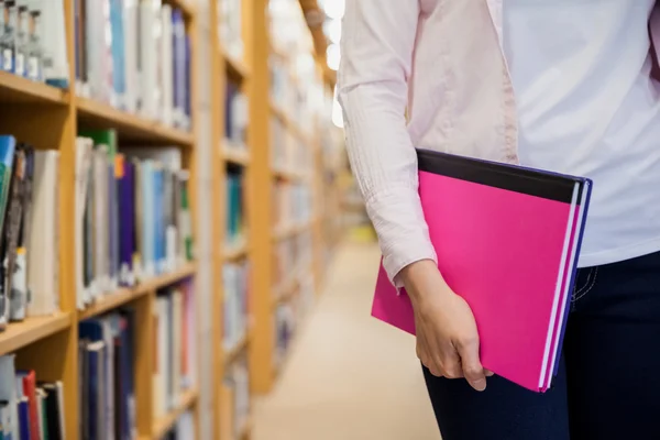 Étudiante détenant des manuels scolaires à la bibliothèque — Photo