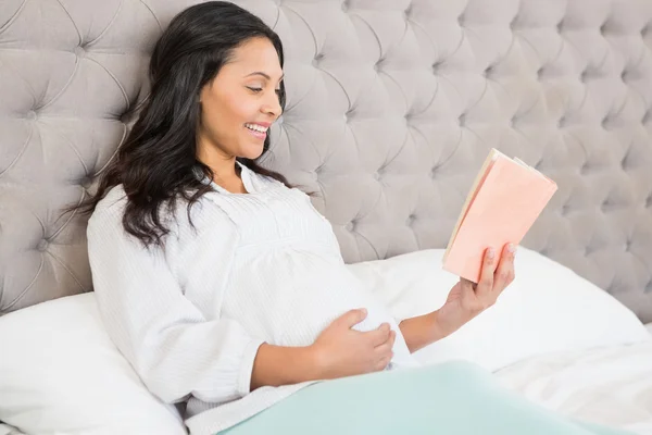 Gravid brunett läser en bok — Stockfoto