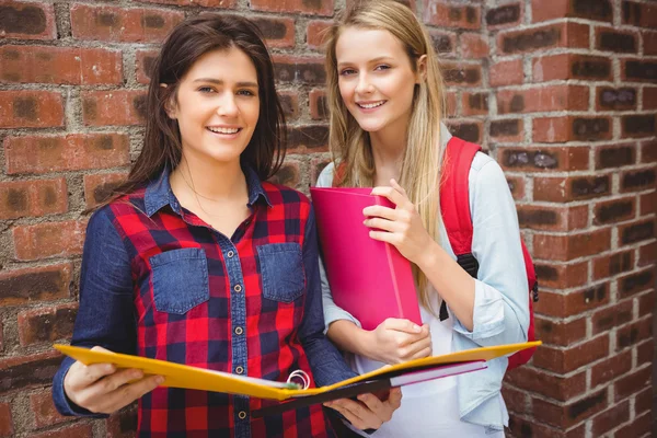 Uśmiechający się studentów z segregatora patrząc na kamery — Zdjęcie stockowe