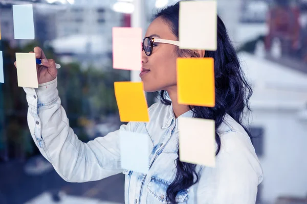 Mujer asiática escribiendo en notas adhesivas —  Fotos de Stock