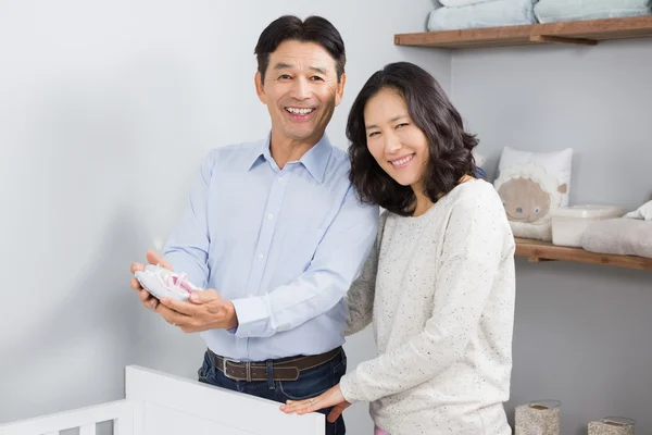 Casal segurando sapatos de bebê — Fotografia de Stock