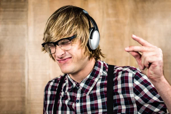 Fröhlicher blonder Hipster hört Musik — Stockfoto