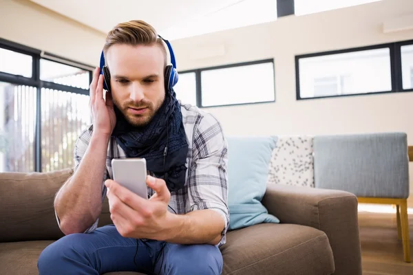 Homem ouvindo música no sofá — Fotografia de Stock