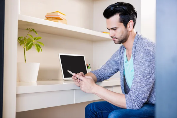 Hombre reflexivo usando teléfono inteligente y portátil — Foto de Stock