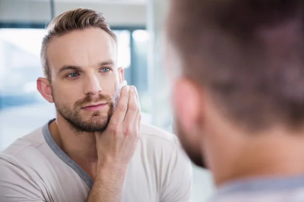 Concentrated man shaving his beard — Stock Photo, Image