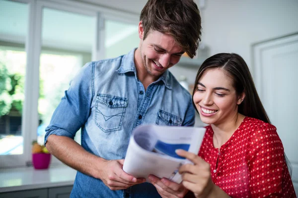 Pareja feliz leyendo periódico —  Fotos de Stock