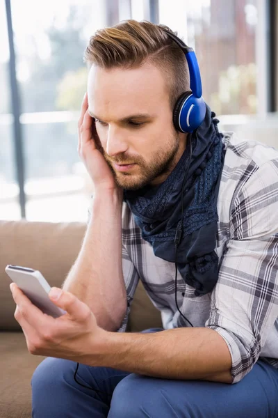 Knappe man luisteren muziek op Bank — Stockfoto