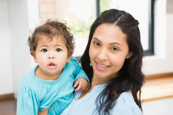 Morena sorridente segurando seu bebê — Fotografia de Stock