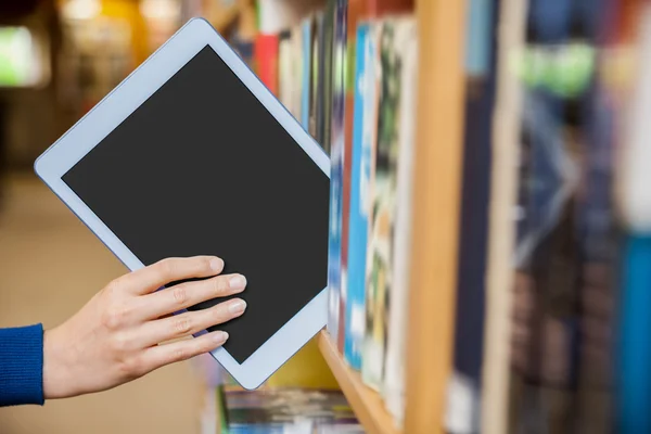 Vrouwelijke student tidyin tablet in boekenkast — Stockfoto