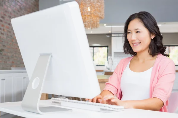 Uśmiechnięta kobieta korzystająca z komputera — Zdjęcie stockowe