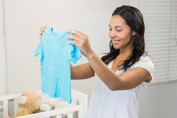 Brunetka, trzymając dziecko tshirt — Zdjęcie stockowe