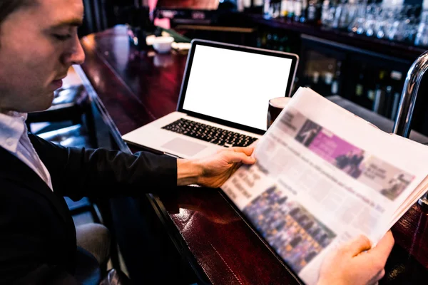 Empresario leyendo noticias y usando laptop — Foto de Stock