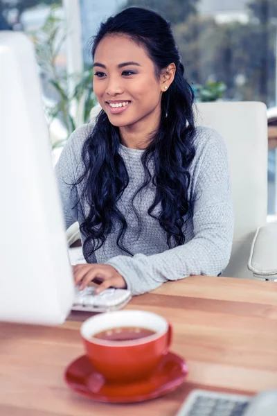 Lachende Aziatische vrouw met behulp van computer — Stockfoto
