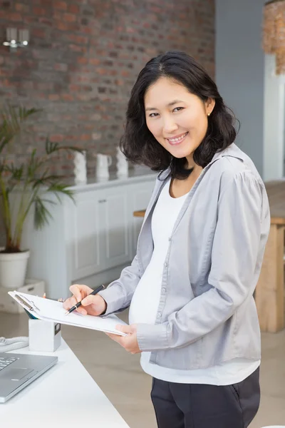 Pregnant woman reading documents — Stockfoto