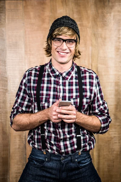 Smiling blond hipster holding smartphone — Stock Photo, Image