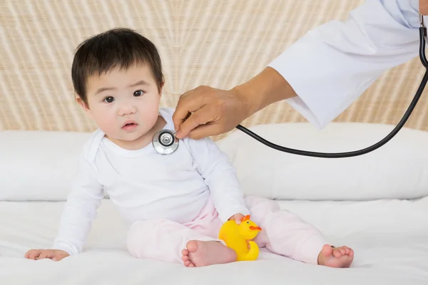 Cute baby being visited by doctor — Stockfoto