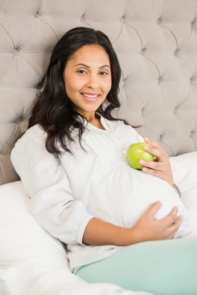 Brune enceinte tenant pomme — Photo