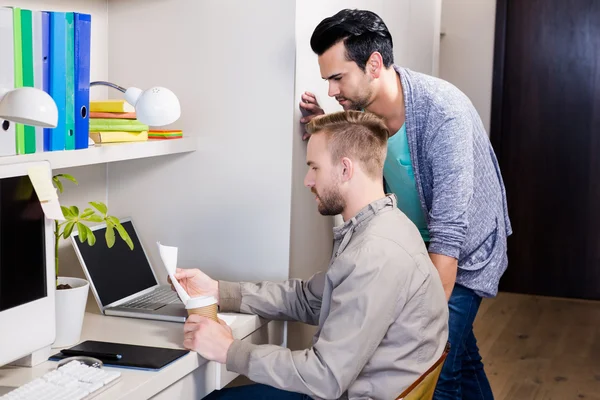 Focused gay couple looking at papers — Stock Photo, Image