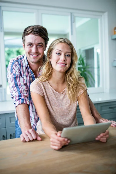 Couple using tablet in kitchen — Stock Photo, Image