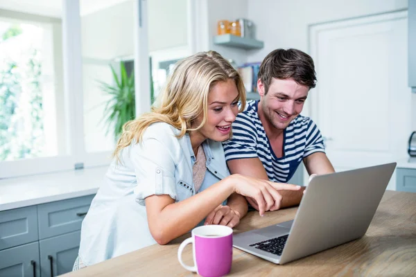 Couple souriant tapant sur ordinateur portable — Photo