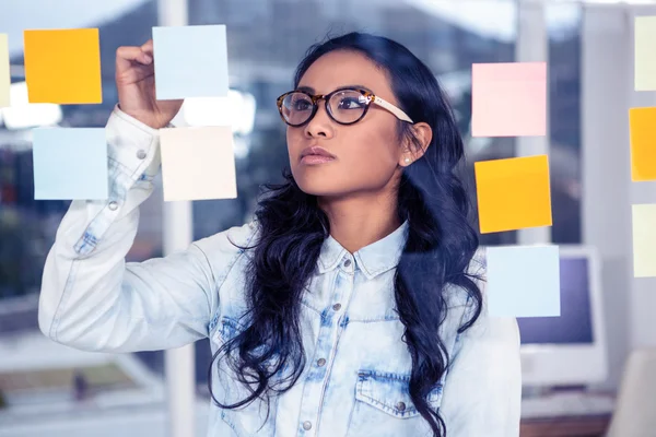 Mulher asiática olhando para notas pegajosas — Fotografia de Stock