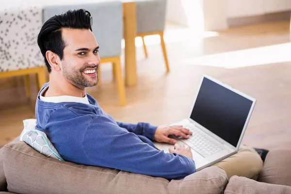 Knappe man met behulp van de laptop op de Bank — Stockfoto