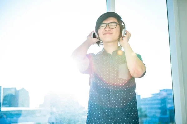 Азиатский бизнесмен слушает музыку — стоковое фото