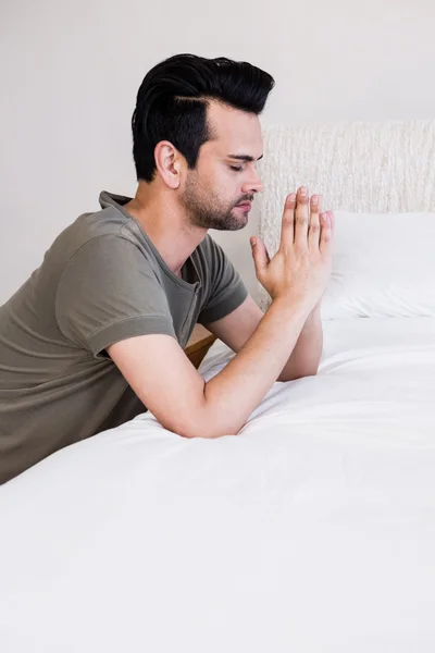 英俊的男人在睡觉前祈祷 — 图库照片