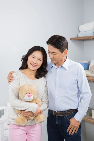 Smiling couple with teddy bear — Stock fotografie