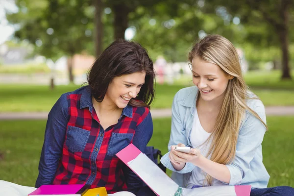 Smiling students using smartphone — Stock Photo, Image