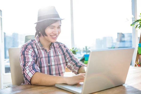 Smiling hipster businessman using laptop — Stock Photo, Image