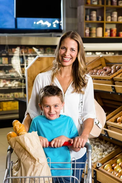 Smiling mother and son with cart — Stock Photo, Image