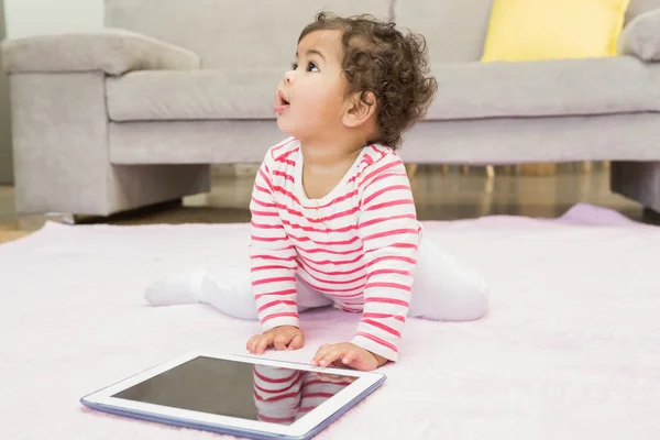 Baby on carpet with tablet — Stock fotografie