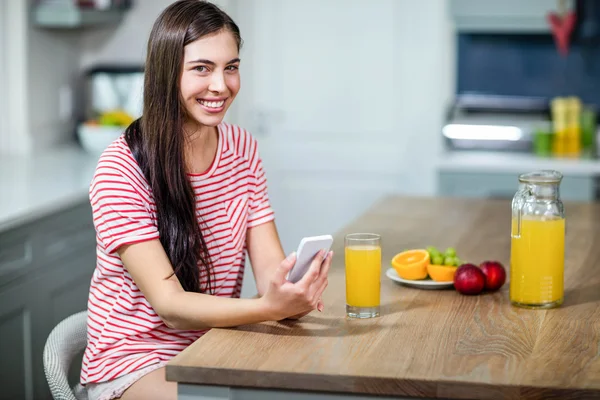 Lachende brunette met smartphone — Stockfoto