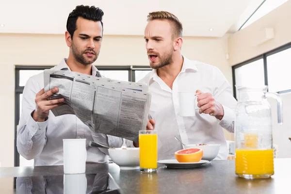 Geconcentreerd homo paar krant lezen — Stockfoto