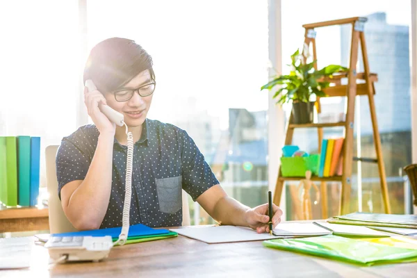 Business man writing and holding telephone — стоковое фото