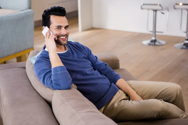 Bonito homem chamando no sofá — Fotografia de Stock