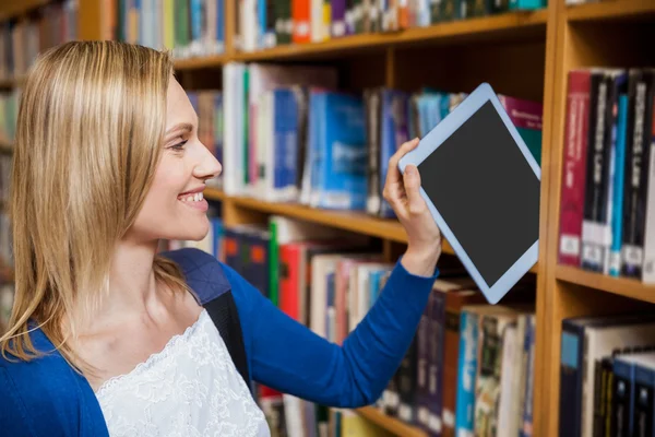 Mujer estudiante ordenando tableta en estantería —  Fotos de Stock